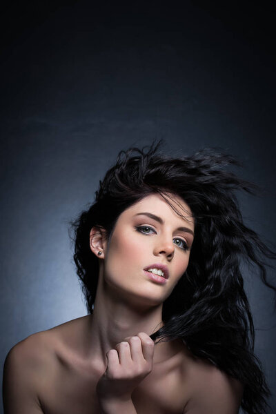 Beautiful brunette model in a studio with a dark background