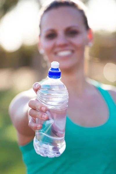 Athletin hält ihre Wasserflasche hoch — Stockfoto