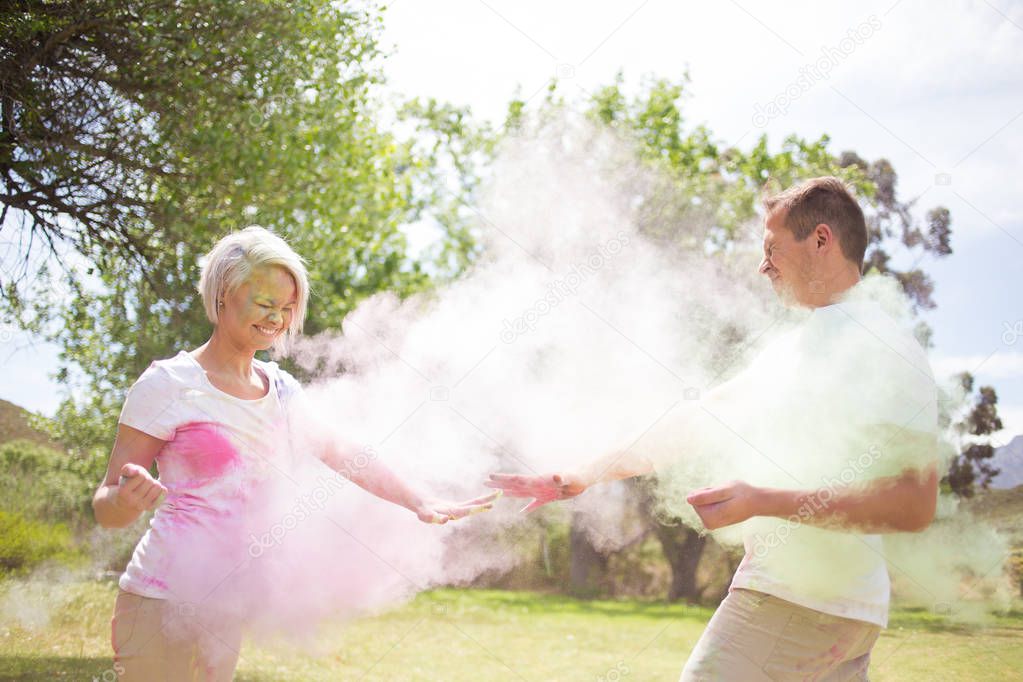  couple playing with colourful  paint powder