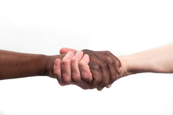 Kaukasische mens aangrijpend een Afrikaanse menselijke hand — Stockfoto