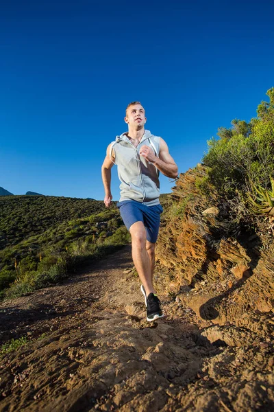 Male fitness model running along a trail — Stock Photo, Image