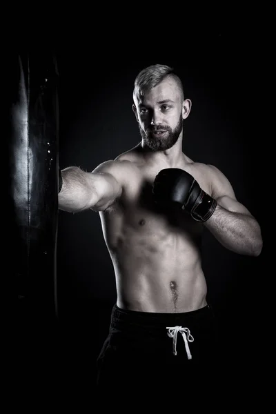Hombre atleta boxeador perforando un saco de boxeo — Foto de Stock