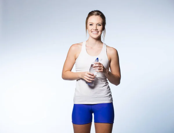 Modèle de fitness tenant une bouteille d'eau — Photo