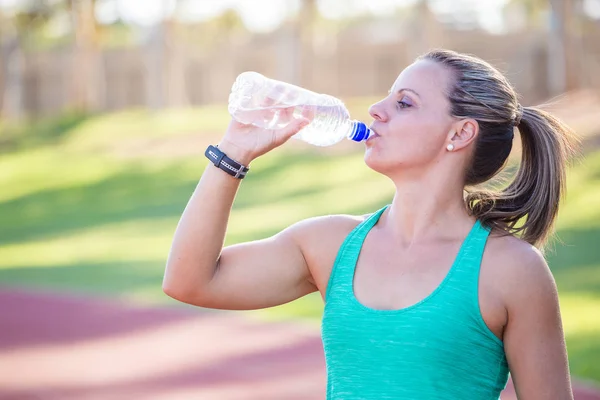 athlete holding out her water bottle