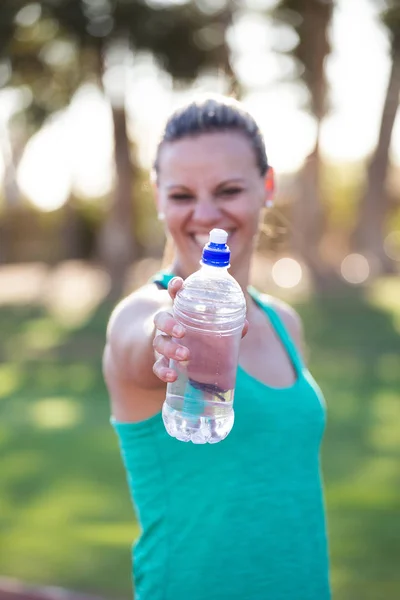 Athletin hält ihre Wasserflasche hoch — Stockfoto