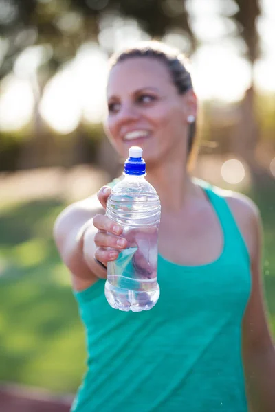 Athlete holding out her water bottle — Stock Photo, Image