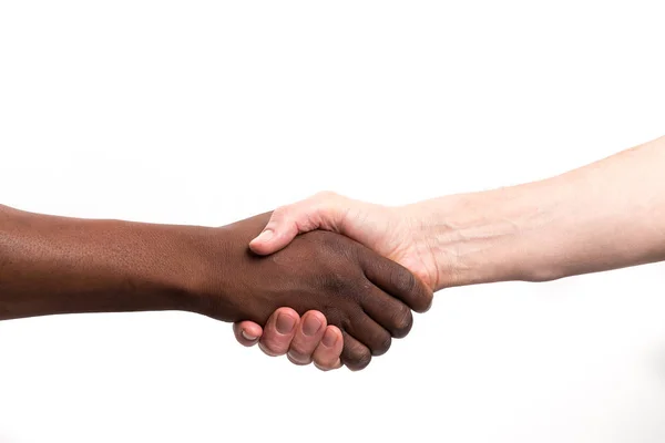 Kaukasische mens aangrijpend een Afrikaanse menselijke hand — Stockfoto