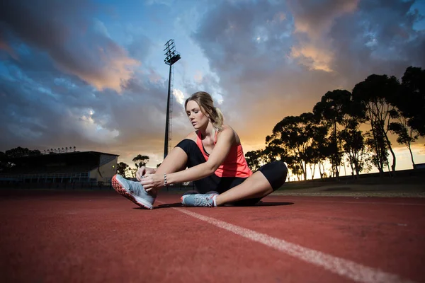 Hermoso modelo de fitness femenino estiramiento y entrenamiento en el atlet — Foto de Stock