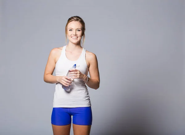 Modello fitness con in mano una bottiglia d'acqua — Foto Stock