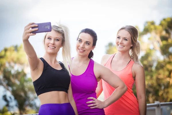 Três mulheres fitness tomando uma selfie — Fotografia de Stock