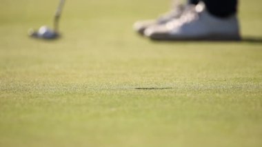 bir golf sahası üzerinde bir yeşil koyarak golfçü