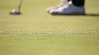 bir golf sahası üzerinde bir yeşil koyarak golfçü