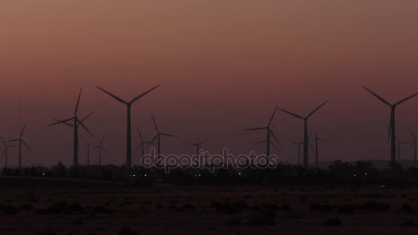 Wind farm as seen from far at dusk — стоковое видео