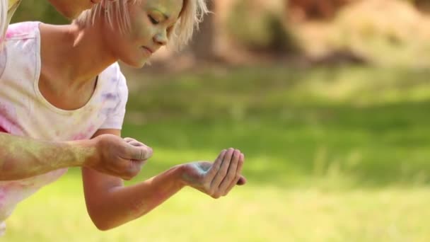 Couple jouant avec de la poudre de peinture colorée — Video