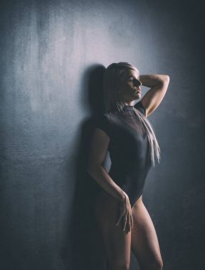 Seksi kadın fitness modeli dramatik aydınlatma ile bir stüdyoda ve