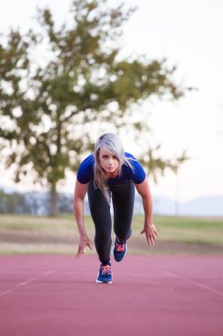 Kadın atlet bir tartan Atletizm yolda Sprint