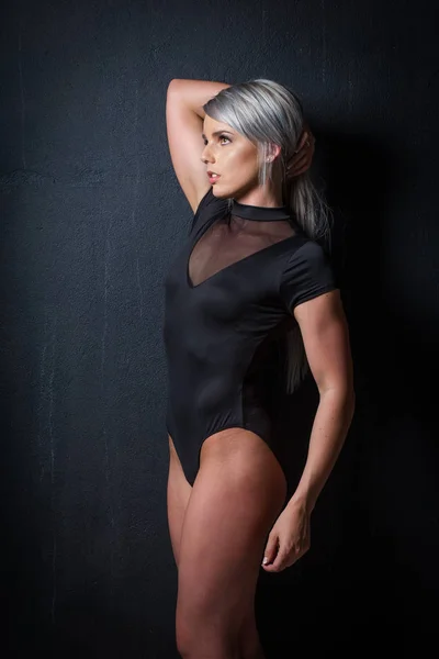 Sexy modelo de fitness femenino en un estudio con iluminación dramática y — Foto de Stock