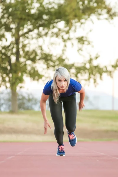Atlet wanita berlari di lintasan atletik tartan — Stok Foto