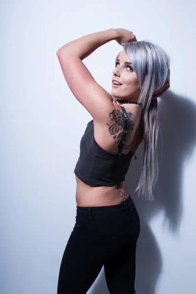 Sexy modelo de fitness femenino en un estudio con iluminación dramática y — Foto de Stock