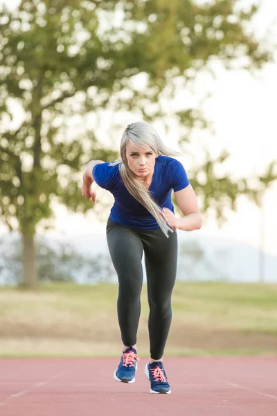 타탄 육상 트랙 역주 하는 여자 선수 — 스톡 사진