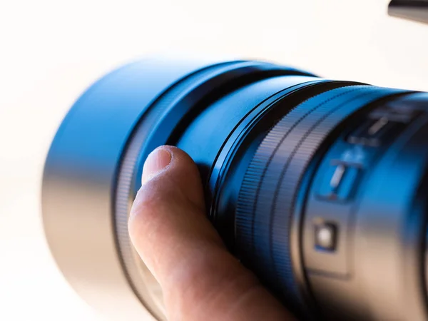 Närbild på en kamera teleobjektiv som hand innehas av en photogr — Stockfoto