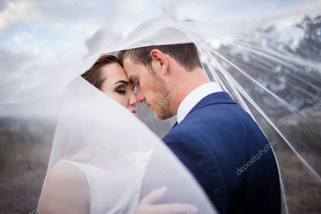 Beautiful bride and her groom on their wedding day looking happy