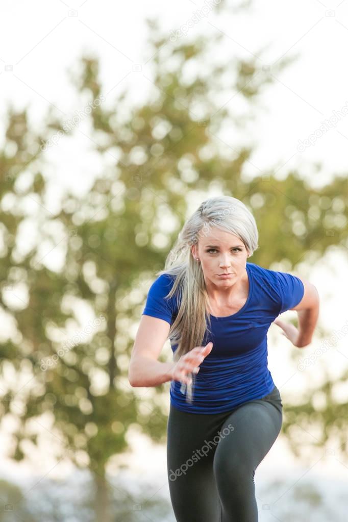 Female athlete sprinting on a tartan athletics track