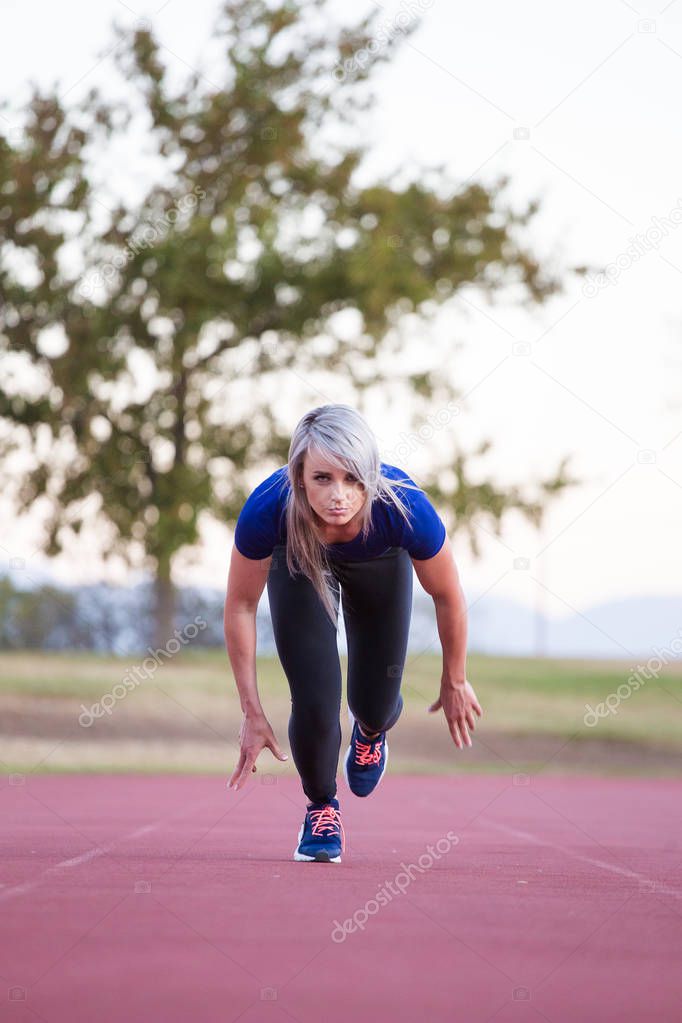 Female athlete sprinting on a tartan athletics track