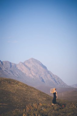 Güzel sarışın kadın model ayakta manzarayı dağlarda