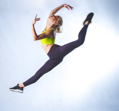 Uzanıyor yapıyor ve beyaz arka plan karşı izole bir stüdyoda dans güzel kadın fitness modeli