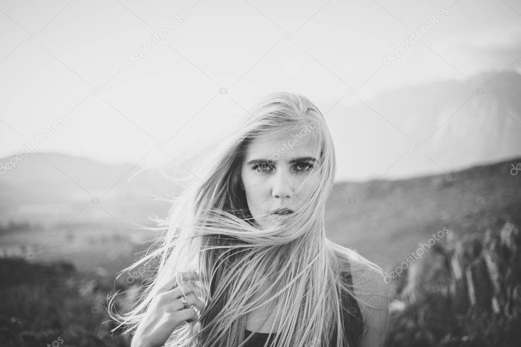 Portrait of a beautiful blonde female model in a natural setting with stunning back light, black and white photo