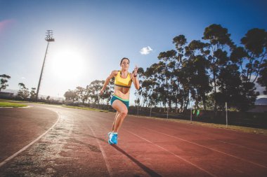 Kadın fitness modeli ve parça atlet tartan yapılan bir atletizm yolda Sprint