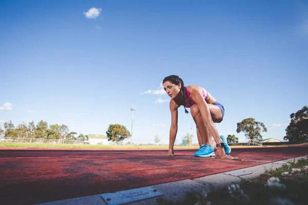 Kadın fitness modeli ve parça atlet tartan yapılan bir atletizm yolda Sprint