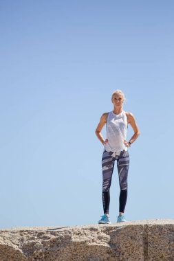 Sarışın kadın modeli meditasyon ve yoga gündüz okyanusa bakan granit kayaya yapıyordum