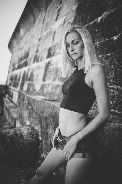 Portret Van Blonde Sportieve Vrouwelijke Model Denim Shorts Bakstenen Muur — Stockfoto