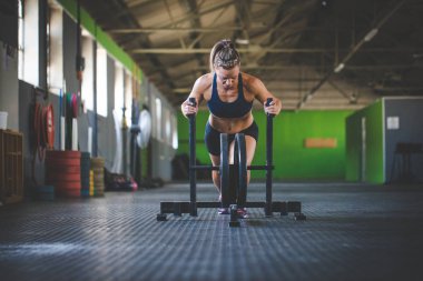Hatun spor salonunda kızağı iten fitness modeli..