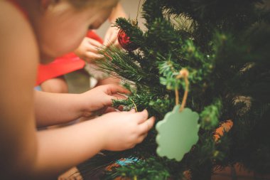 Noel ağacı süsleyen iki genç kız / kız kardeş resmi.
