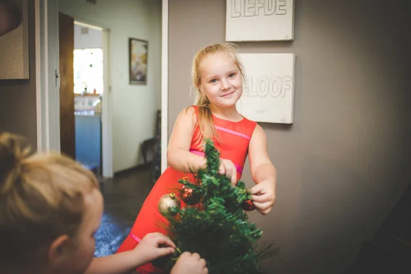 Image rapprochée de deux jeunes filles / sœurs, décorant un sapin de Noël pour les vacances — Photo