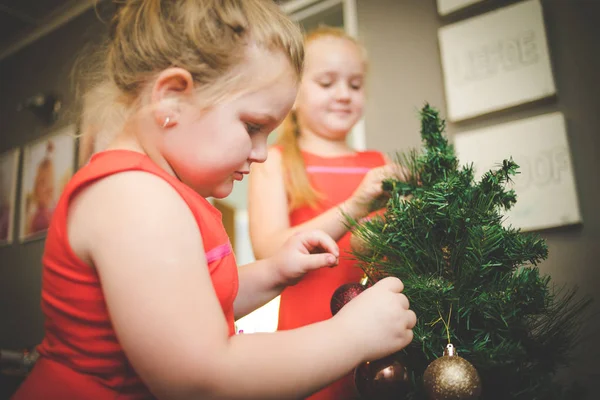 Image rapprochée de deux jeunes filles / sœurs, décorant un sapin de Noël pour les vacances — Photo
