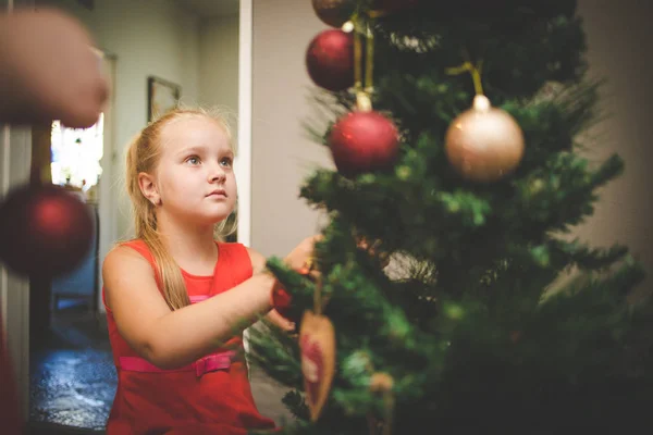 休日のためにクリスマスツリーを飾る画像若い女の子を閉じます — ストック写真