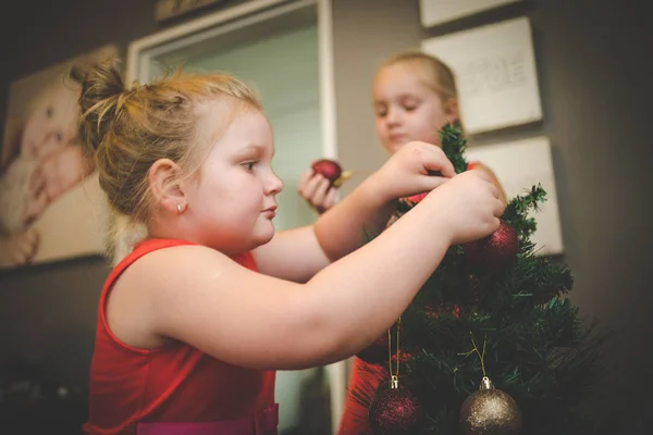 Image rapprochée de deux jeunes filles / sœurs, décorant un sapin de Noël pour les vacances — Photo