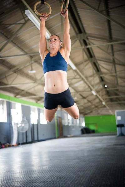 女子健身模特儿把自己拉上来 在体育馆的头顶上进行交叉体能训练 — 图库照片