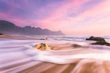 Cape Town, Güney Afrika 'daki Gordonsbay' ın hemen dışındaki Kogelbay 'da çarpıcı bir günbatımının geniş açılı görüntüsü.