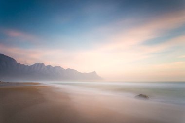 Cape Town, Güney Afrika 'daki Gordonsbay' ın hemen dışındaki Kogelbay 'da çarpıcı bir günbatımının geniş açılı görüntüsü.