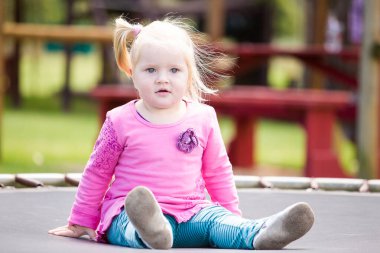 Dışarıda oynayan küçük sarışın bir kızın görüntüsünü kapat.