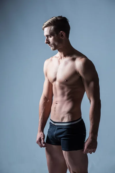 Zbliżenie Obrazu Męskiego Modela Fitness Napinającego Swoje Ciało Studiu — Zdjęcie stockowe