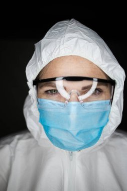 Tehlikeli virüsler için aşılarla çalışan koruyucu giysiler ve maskeler giyen bir sağlık çalışanının portre resmini kapatın.