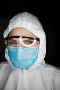 Tehlikeli virüsler için aşılarla çalışan koruyucu giysiler ve maskeler giyen bir sağlık çalışanının portre resmini kapatın.