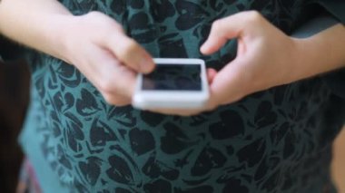 Akıllı telefon kullanan hamile bir kadın.