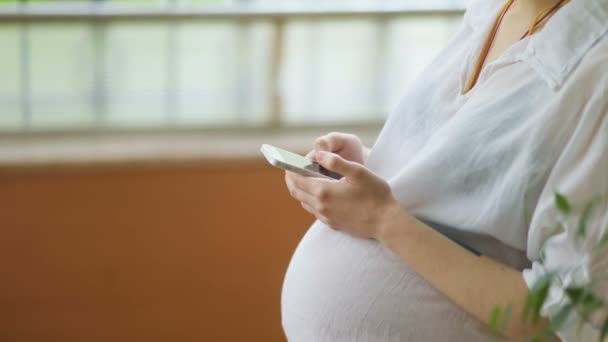 Zwangere vrouw met behulp van smart phone — Stockvideo